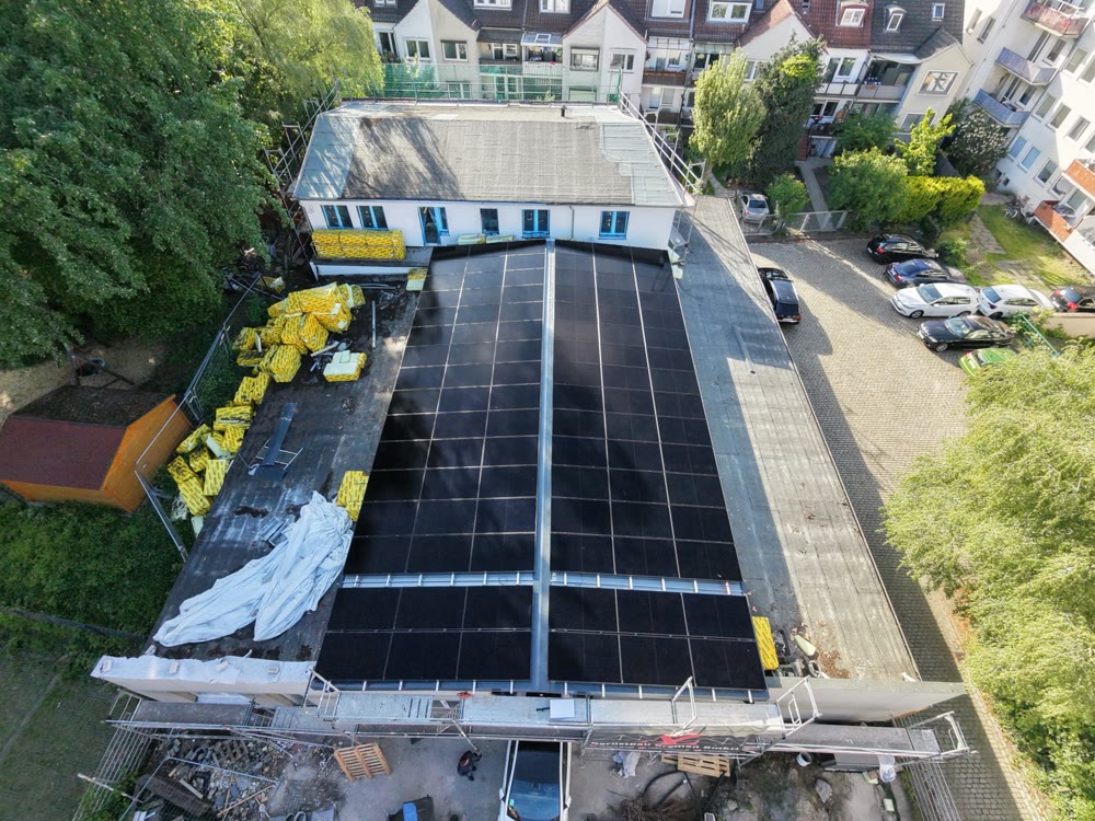 Luftbild von oben: Hallendach komplett mit schwarzen PV-Modulen belegt